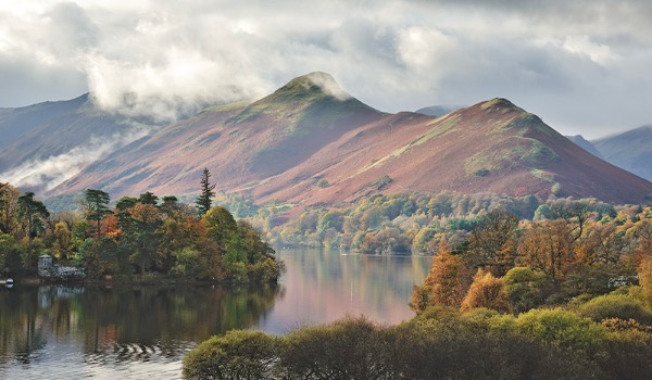 A view across the Lake District with lakes, trees and mountains